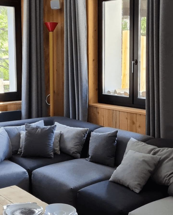 Canapé d’angle et coussins gris dans le salon d’un chalet
